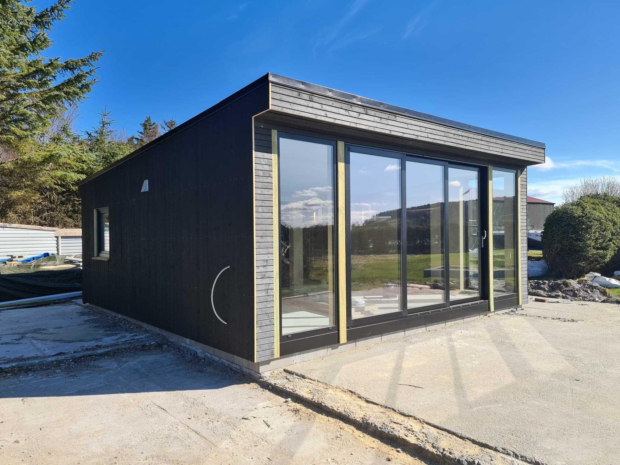 Nytt bygg i sort kledning med store glassfelt