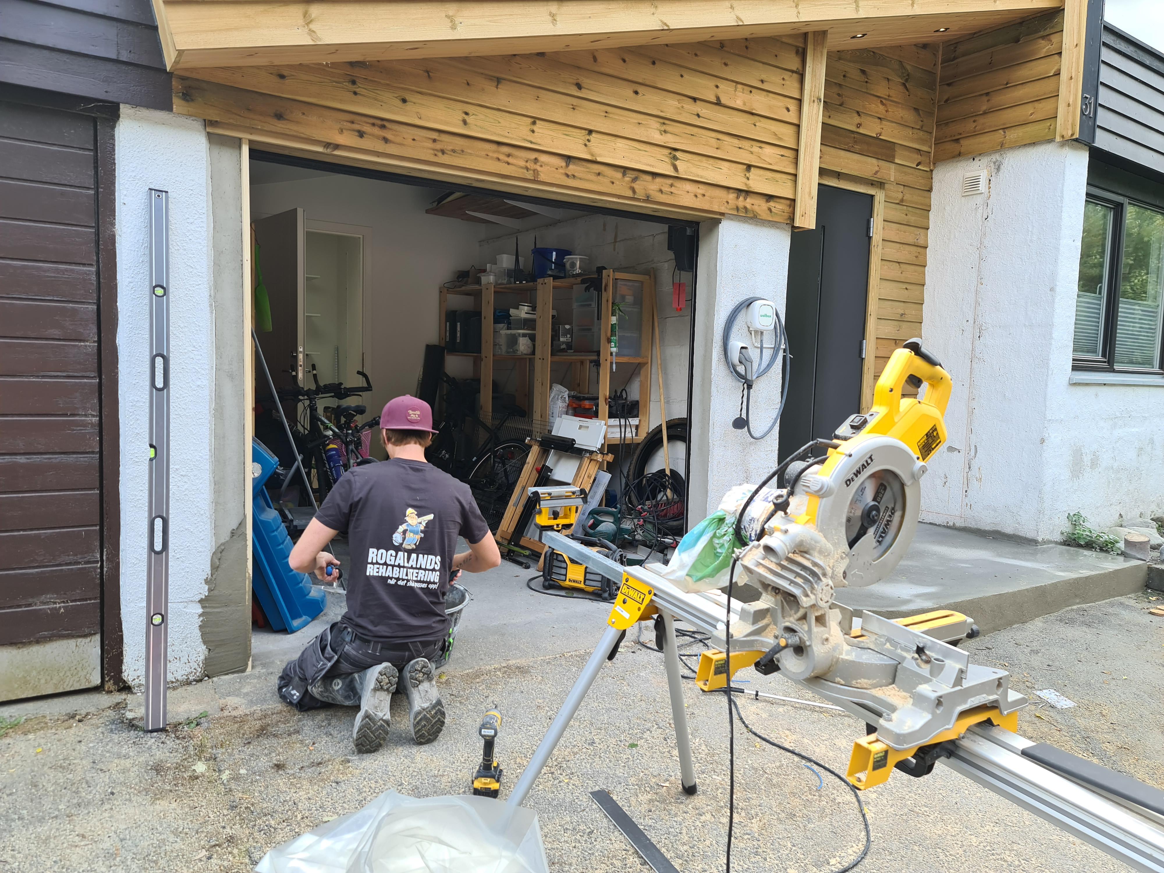 Tømrere fra Rogalands Rehabilitering kapper materialer på byggeplassen for en ny garasje